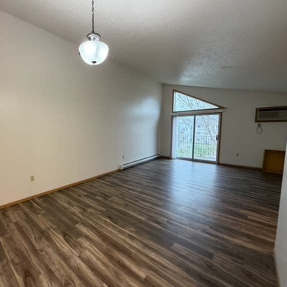 Empty interior space with large windows and wooden flooring