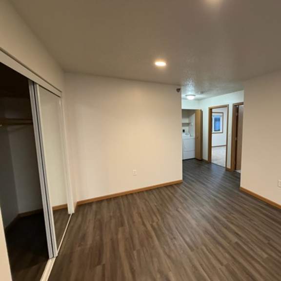 Empty room with hardwood flooring and closet