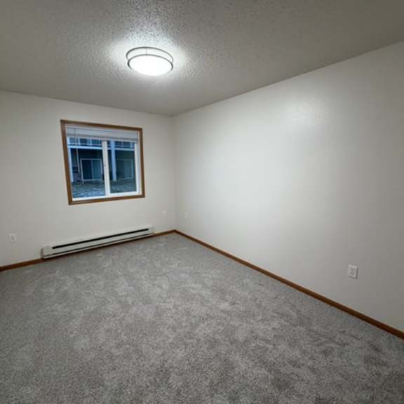 Empty interior room with gray carpet and window