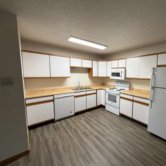 Clean kitchen space with white cabinets and appliances.