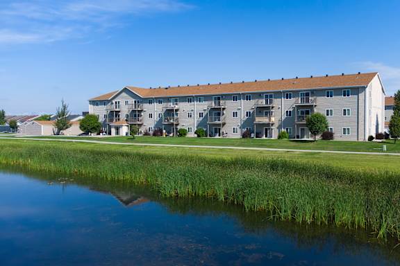 Exterior view of a residential building by a pond