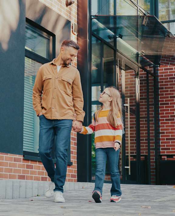 A man and a girl walking outside the facility