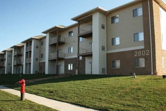 Exterior view of residential buildings and lawn.