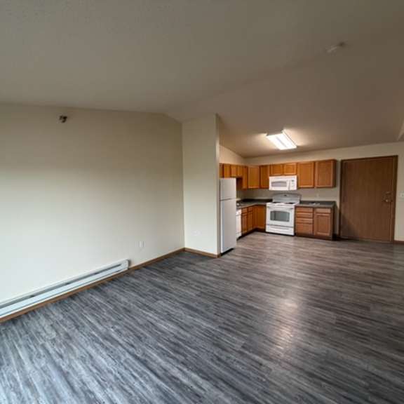 Empty kitchen area with appliances and wooden cabinets