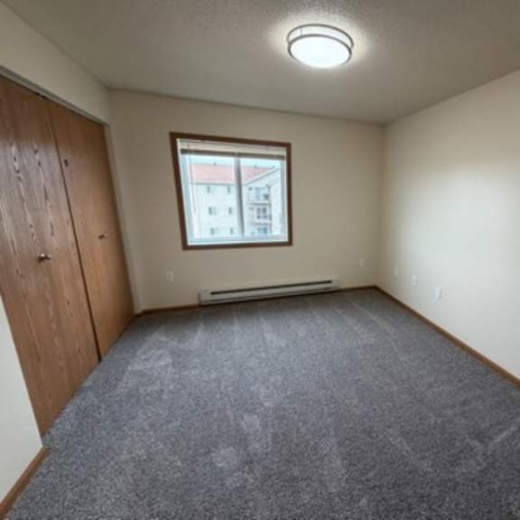 Empty resident room with carpet and window