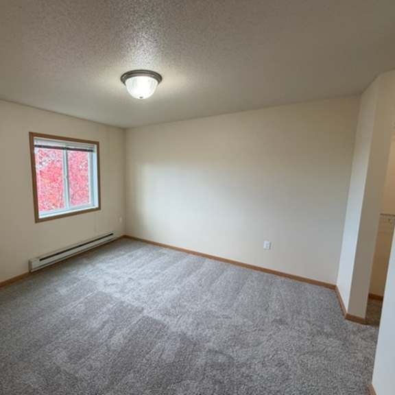 Empty room with light carpeting and a window