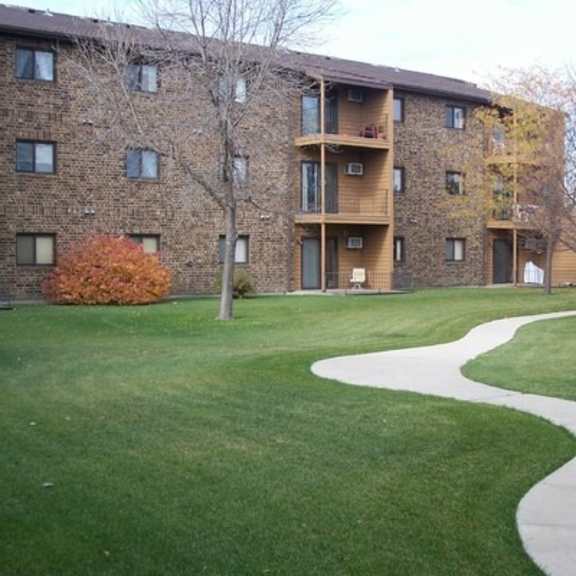 Exterior view of apartment building with landscaped area.
