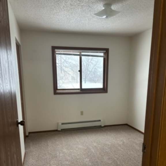 Empty room with a window and carpeted floor