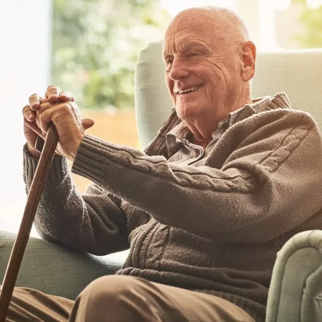 Senior man smiling while sitting in a chair