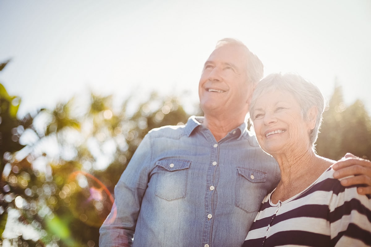 Happy senior couple outdoors in sunlight