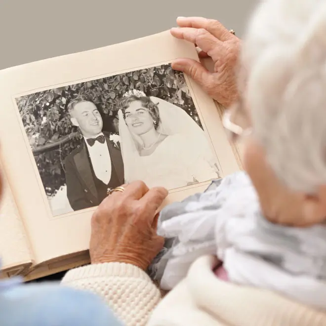 Two seniors looking at a wedding photo together.