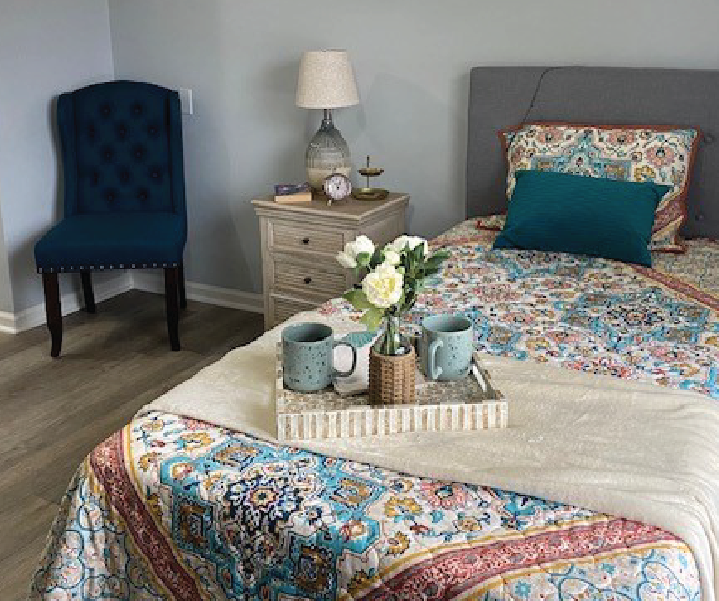 Cozy bedroom with floral bedding and decorative items.