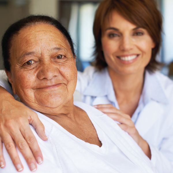 Smiling caregiver with resident in a warm setting
