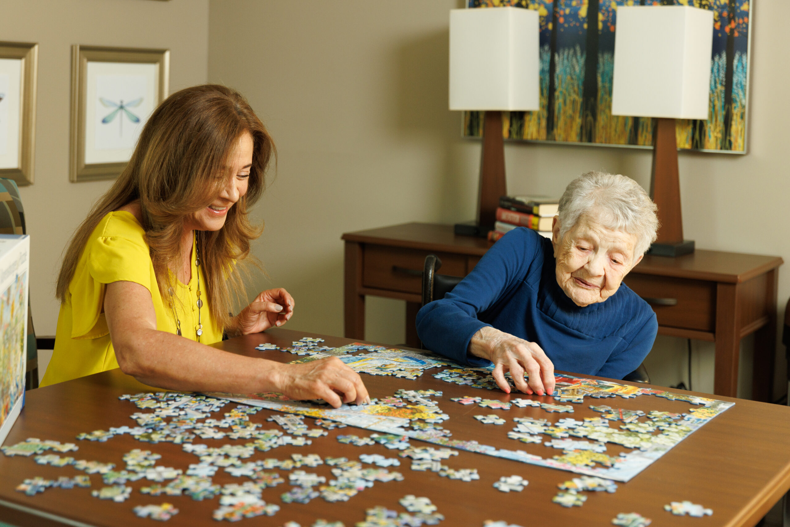 Two women working on a jigsaw puzzle together.