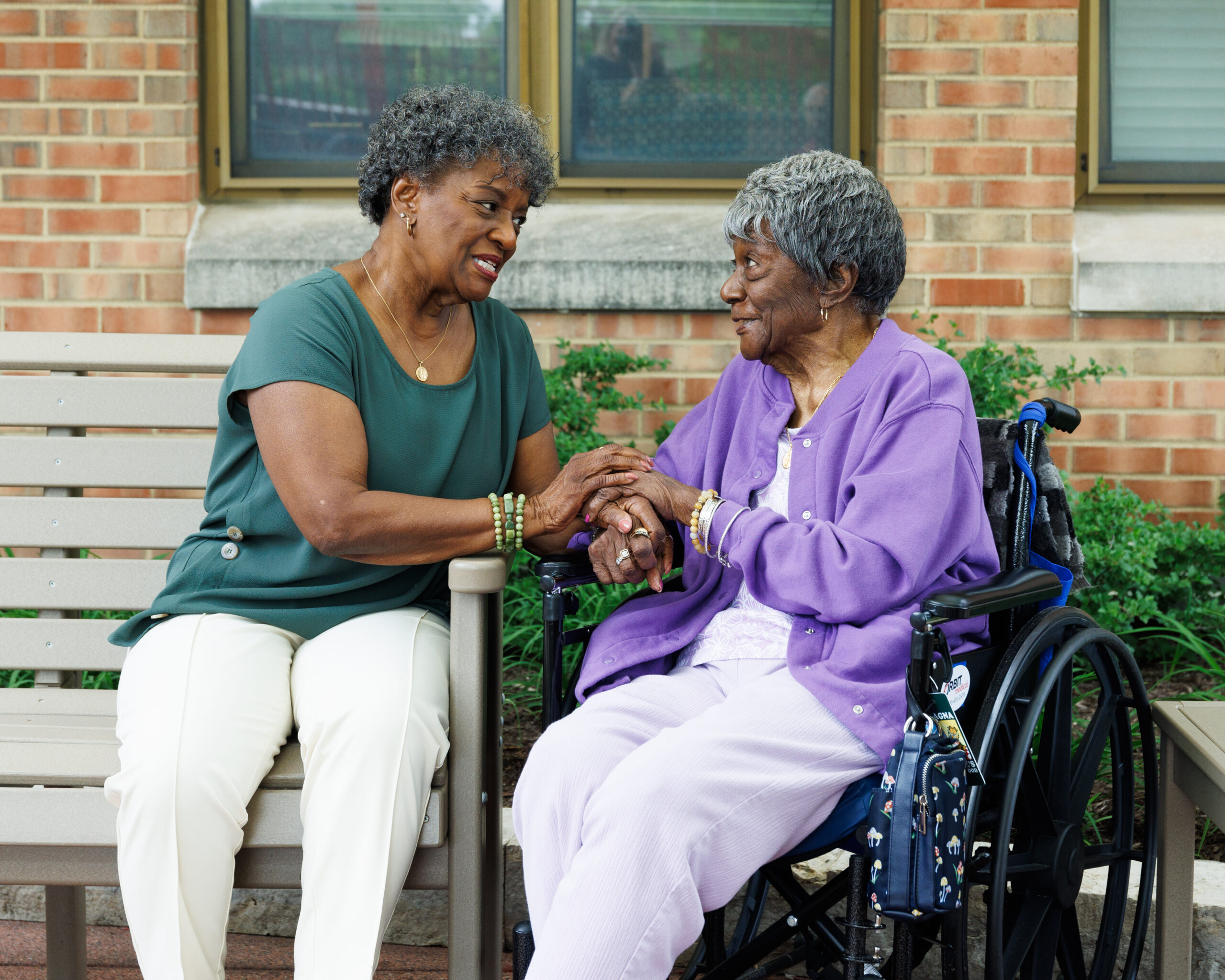 Two seniors sharing a warm moment outdoors.