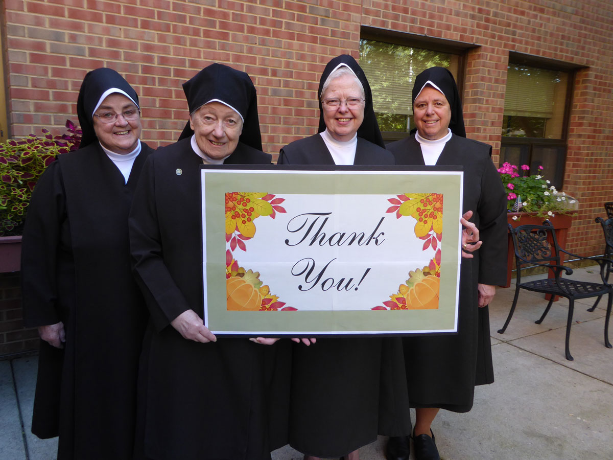 Group of four women holding a thank you sign