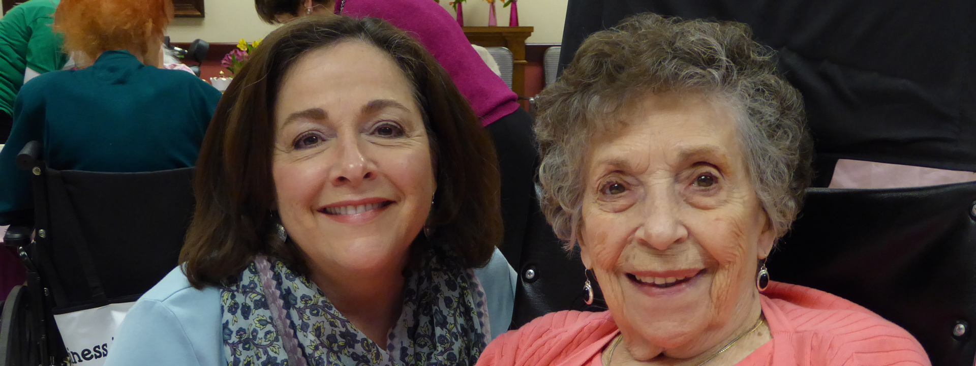 Two women smiling together in a common area