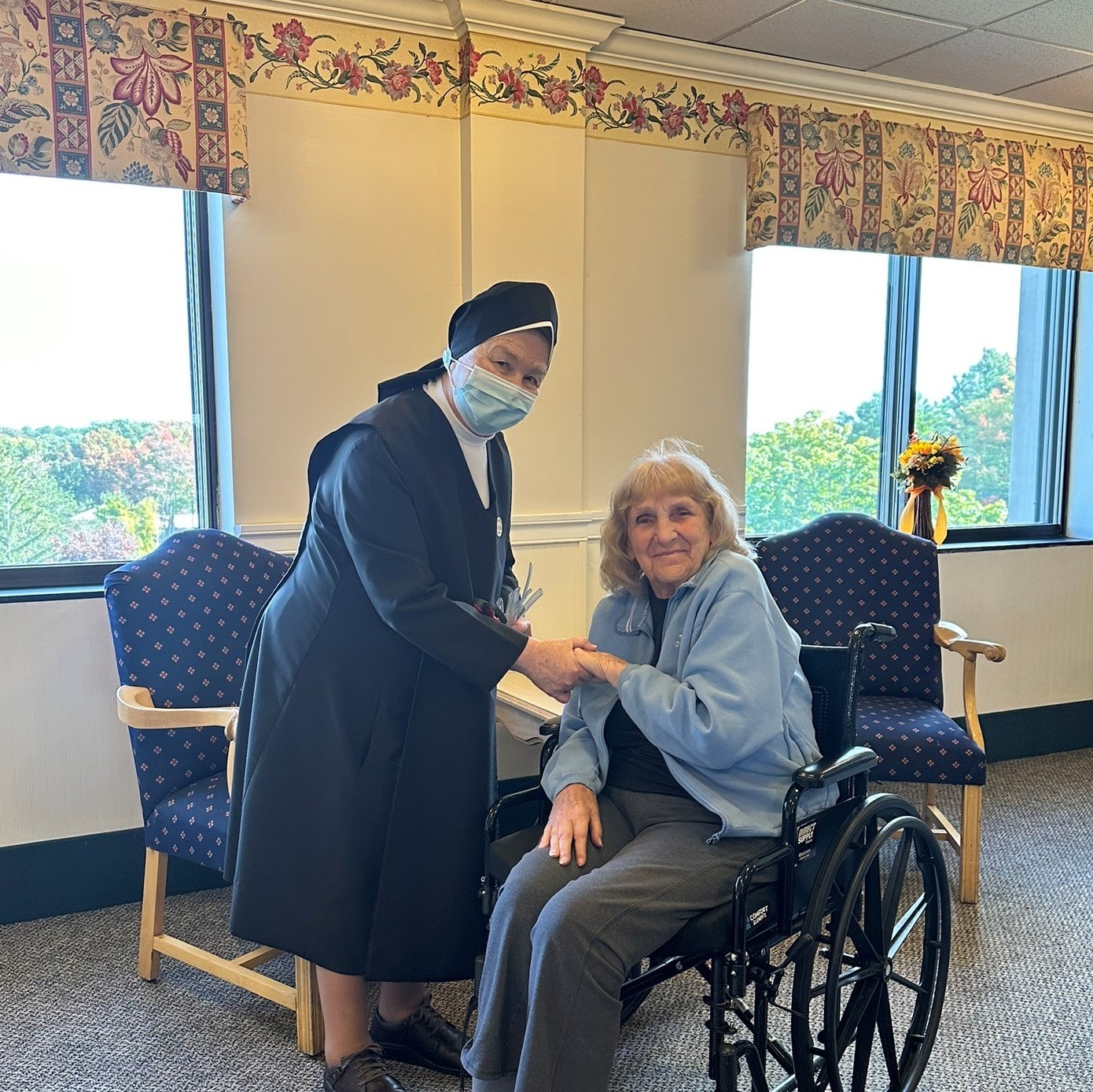 Caregiver assisting a resident in a common area