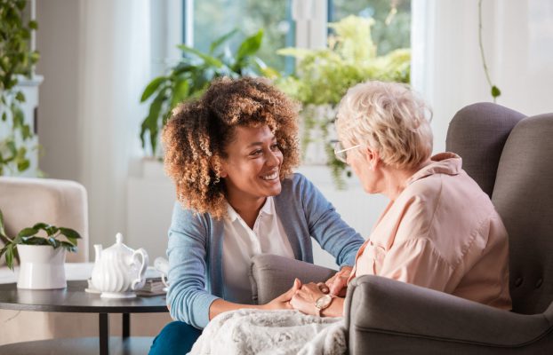 Caregiver engaging with resident in a cozy setting.