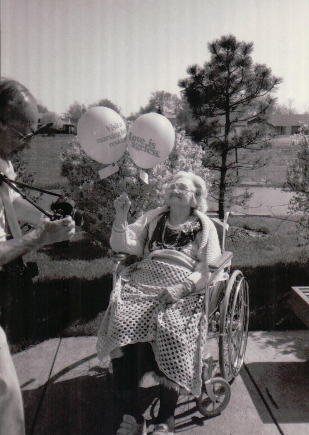 Resident celebrating outdoors with balloons.