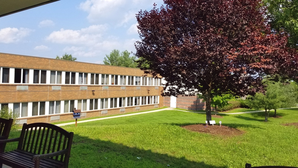 Exterior view of Southtowns Care Center with lawn and trees.