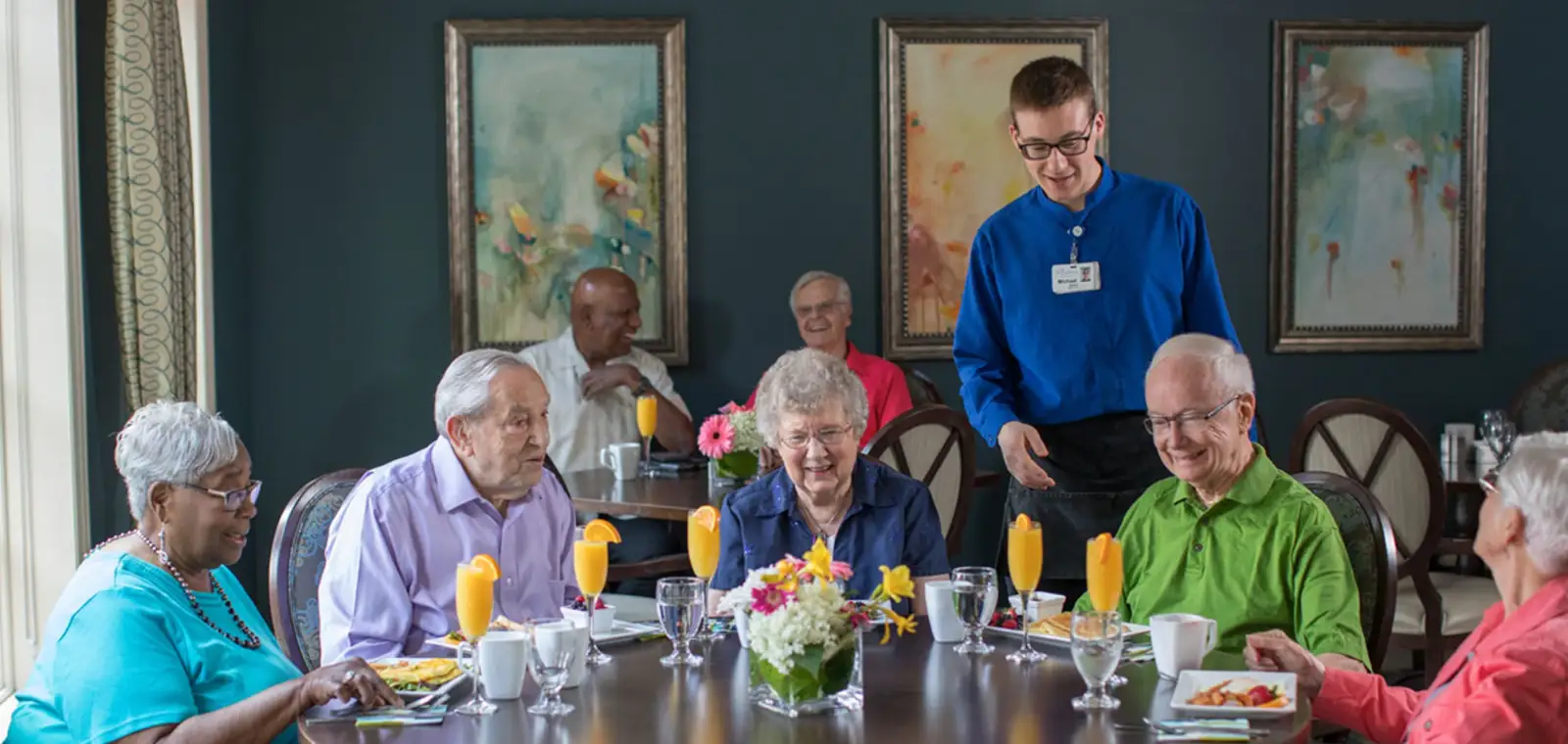 Residents enjoying a meal with a staff member.