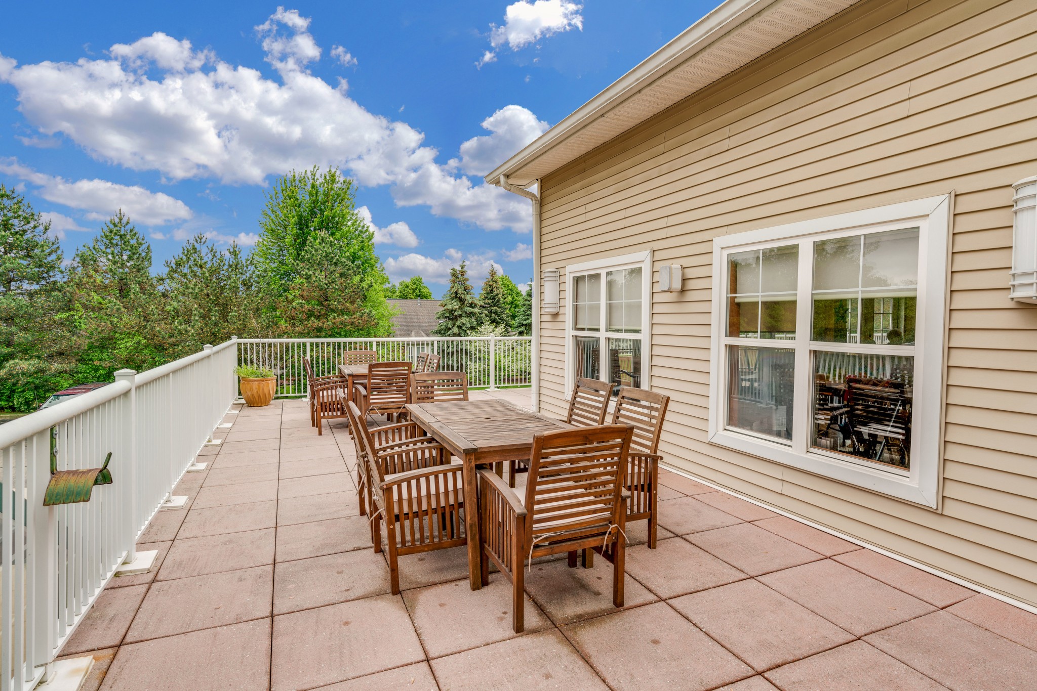 Outdoor patio area with wooden furniture and greenery