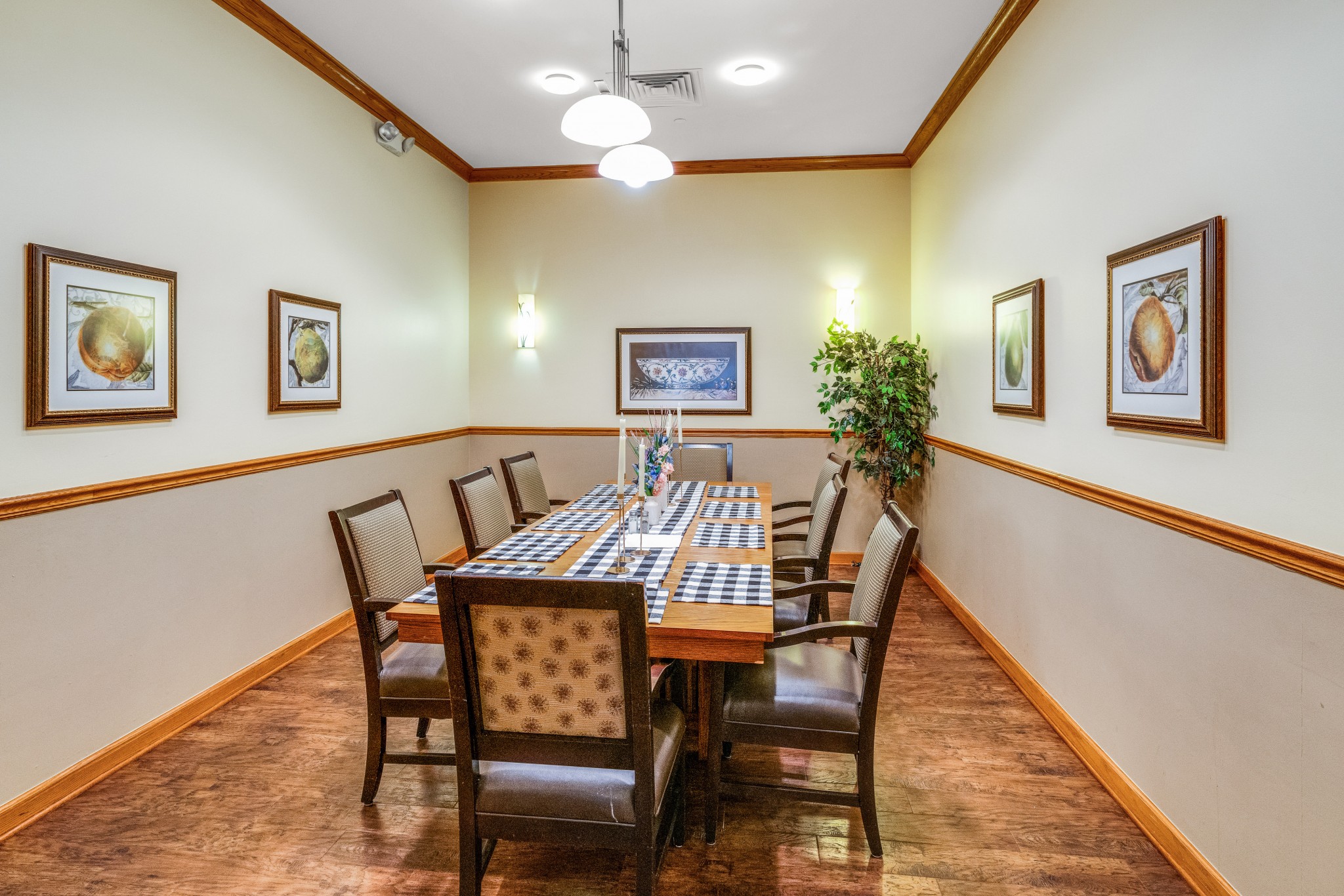 Bright dining room with wooden chairs and framed art