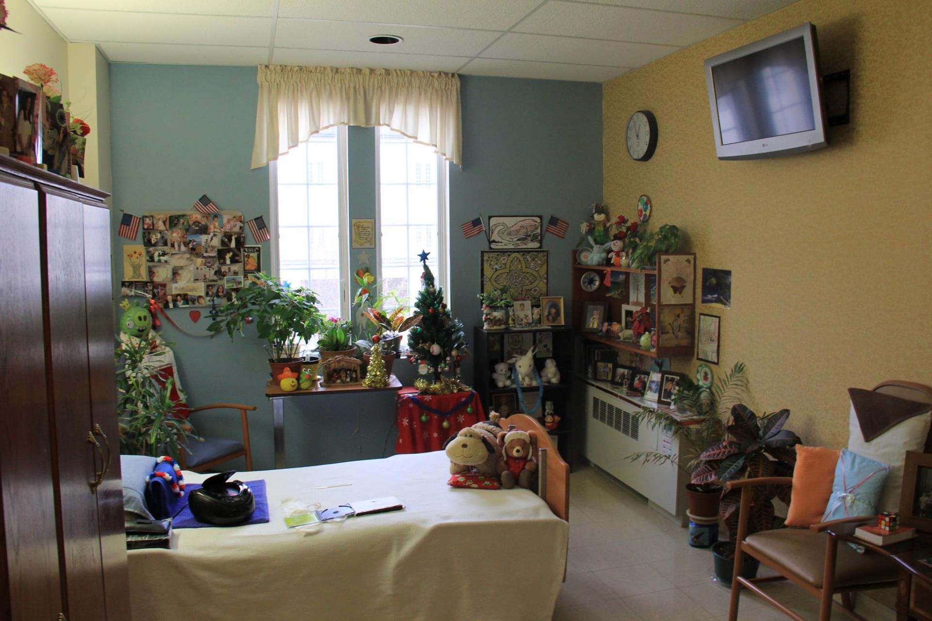 Cozy resident room decorated with personal items and plants.
