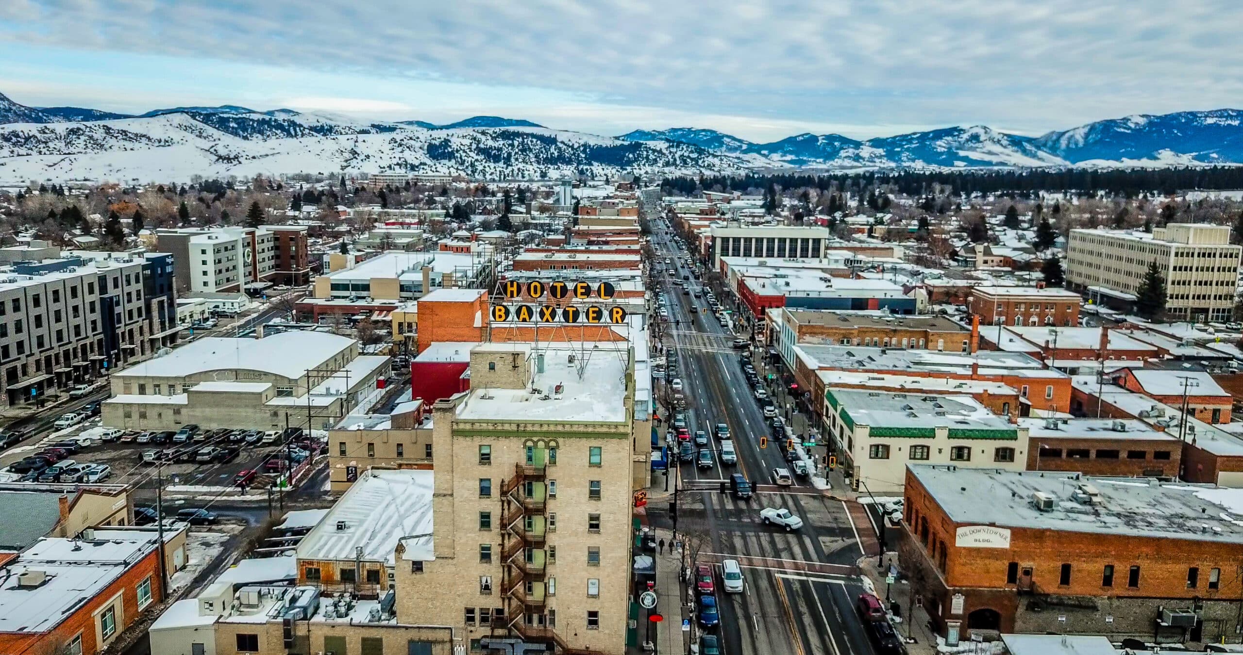 Aerial view of a snowy town with buildings and mountains
