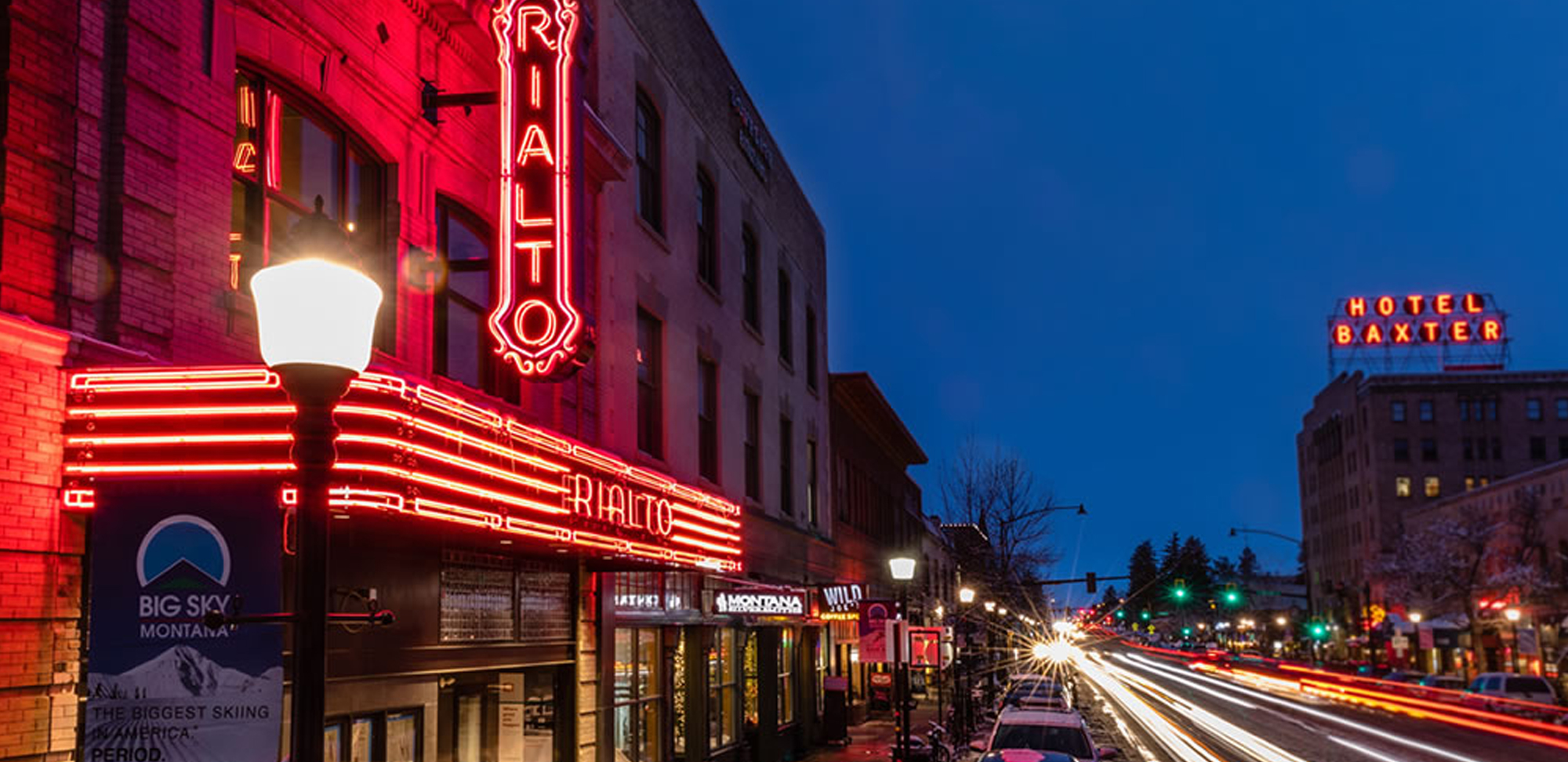 Exterior view of a theater building with neon lights