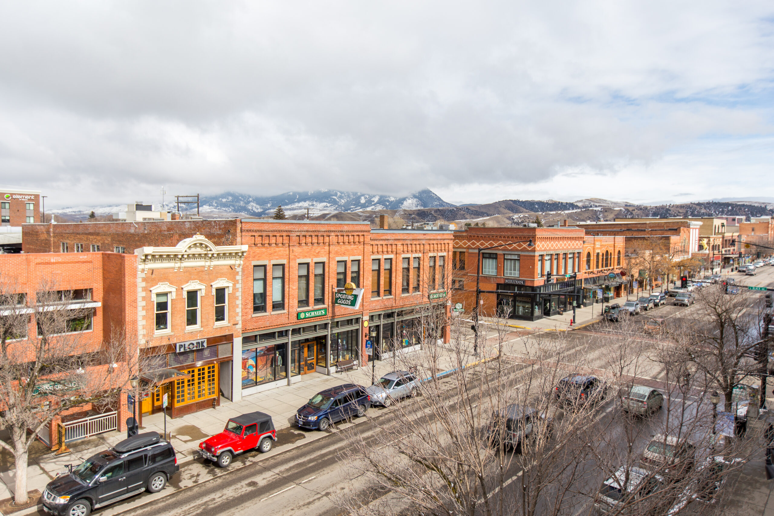 Downtown street view with shops and vehicles