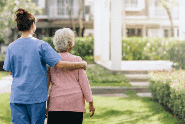 Caregiver assisting a resident in an outdoor space