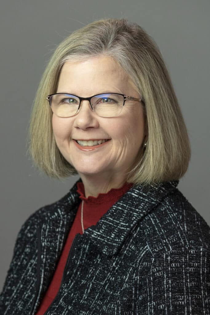 Professional portrait of a smiling woman in a blazer