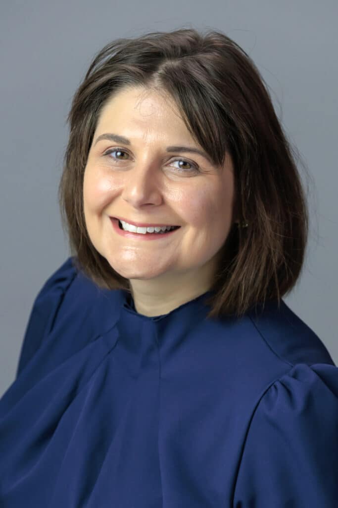 Smiling staff member wearing a navy blue dress