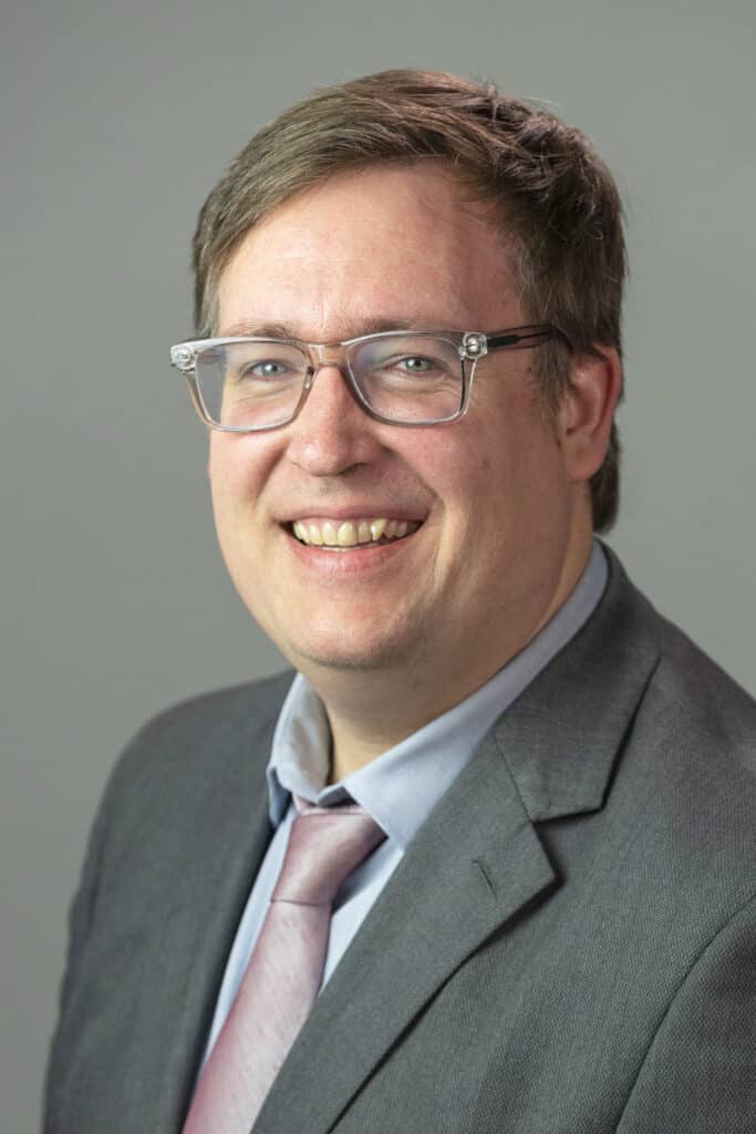 Portrait of a man in a suit with glasses