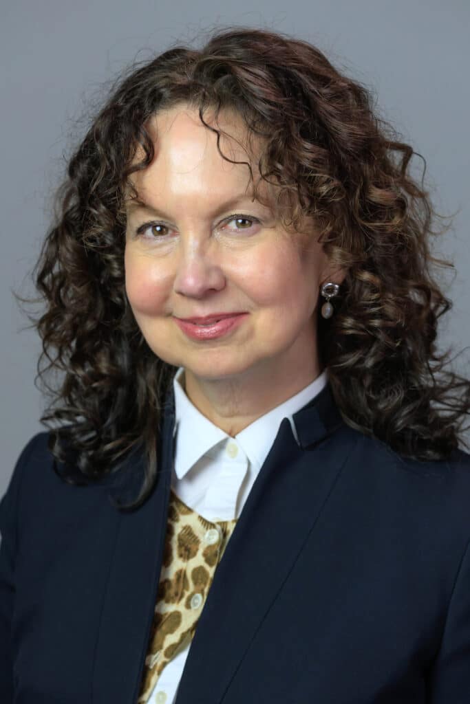 Professional headshot of a woman with curly hair
