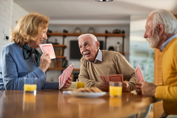 Three residents playing cards at a table