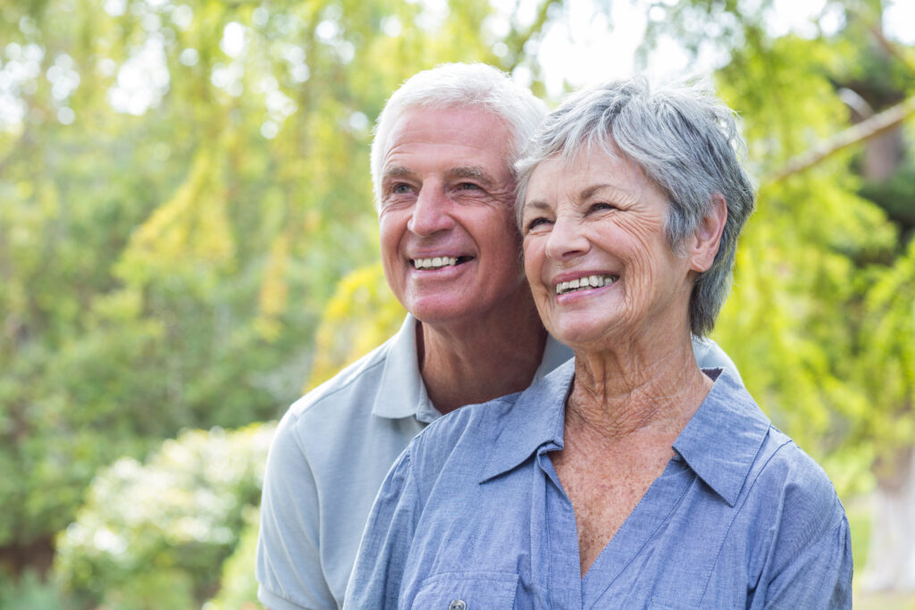 Smiling senior couple outdoors in a garden setting