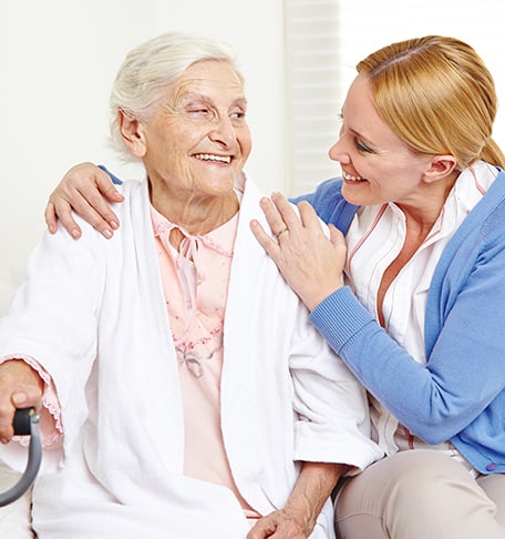 Staff member assisting a smiling resident