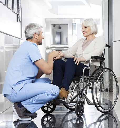 Staff assisting a resident in a wheelchair