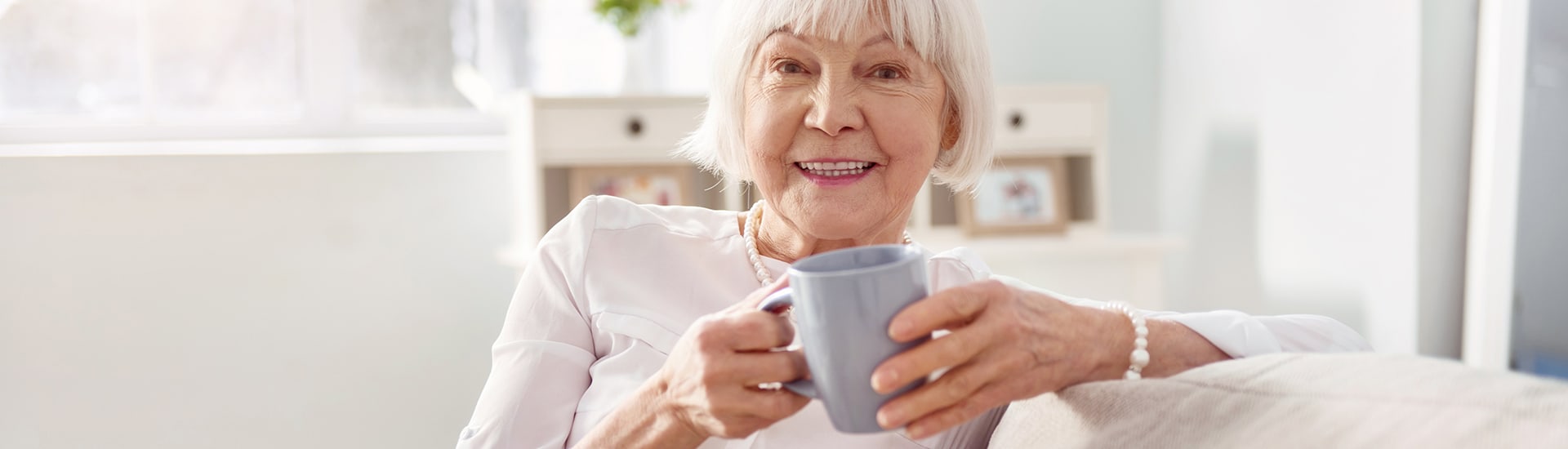 Senior woman enjoying a cup of coffee in a cozy room