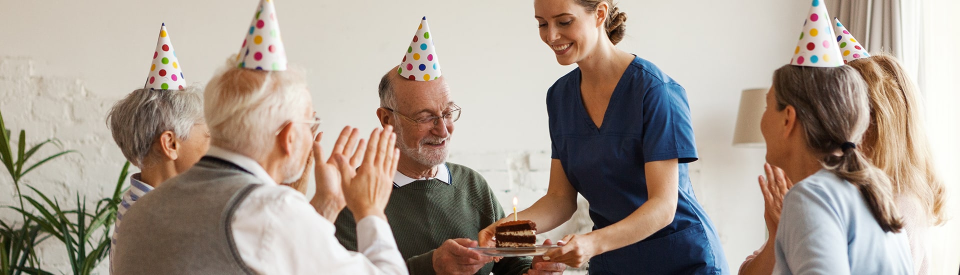 Residents celebrating with a staff member and cake