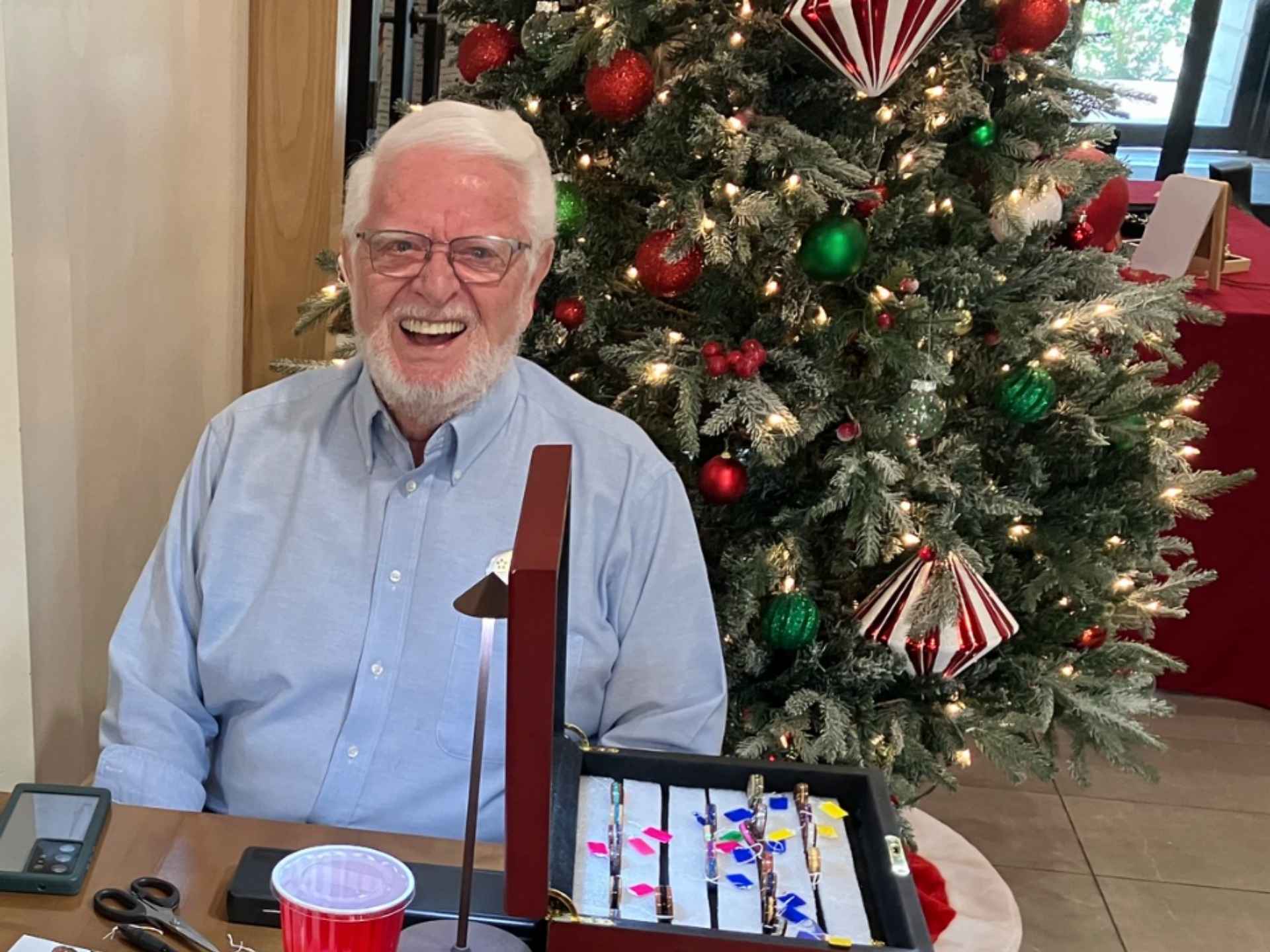 Resident smiling by a decorated Christmas tree