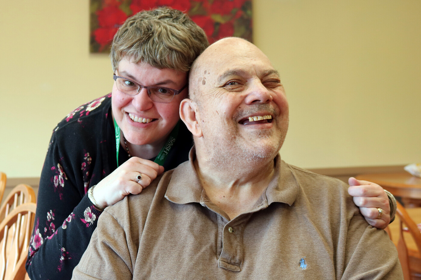 A staff member playfully interacting with a resident in a common area
