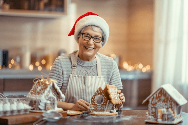 Resident making a gingerbread house during a holiday activity
