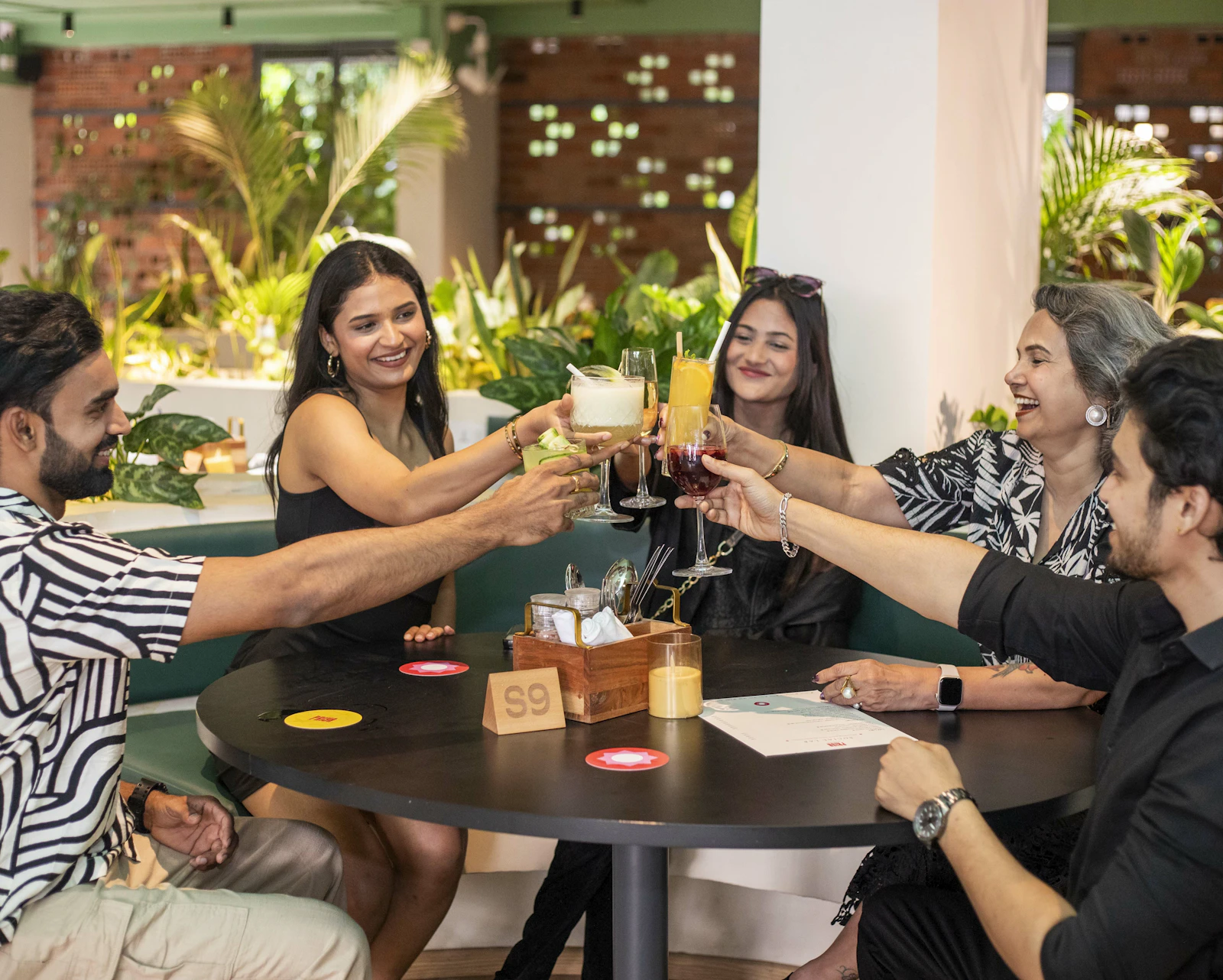 Residents and staff toasting with drinks at a dining area
