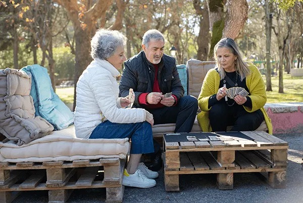 Residents playing cards outdoors in a communal area