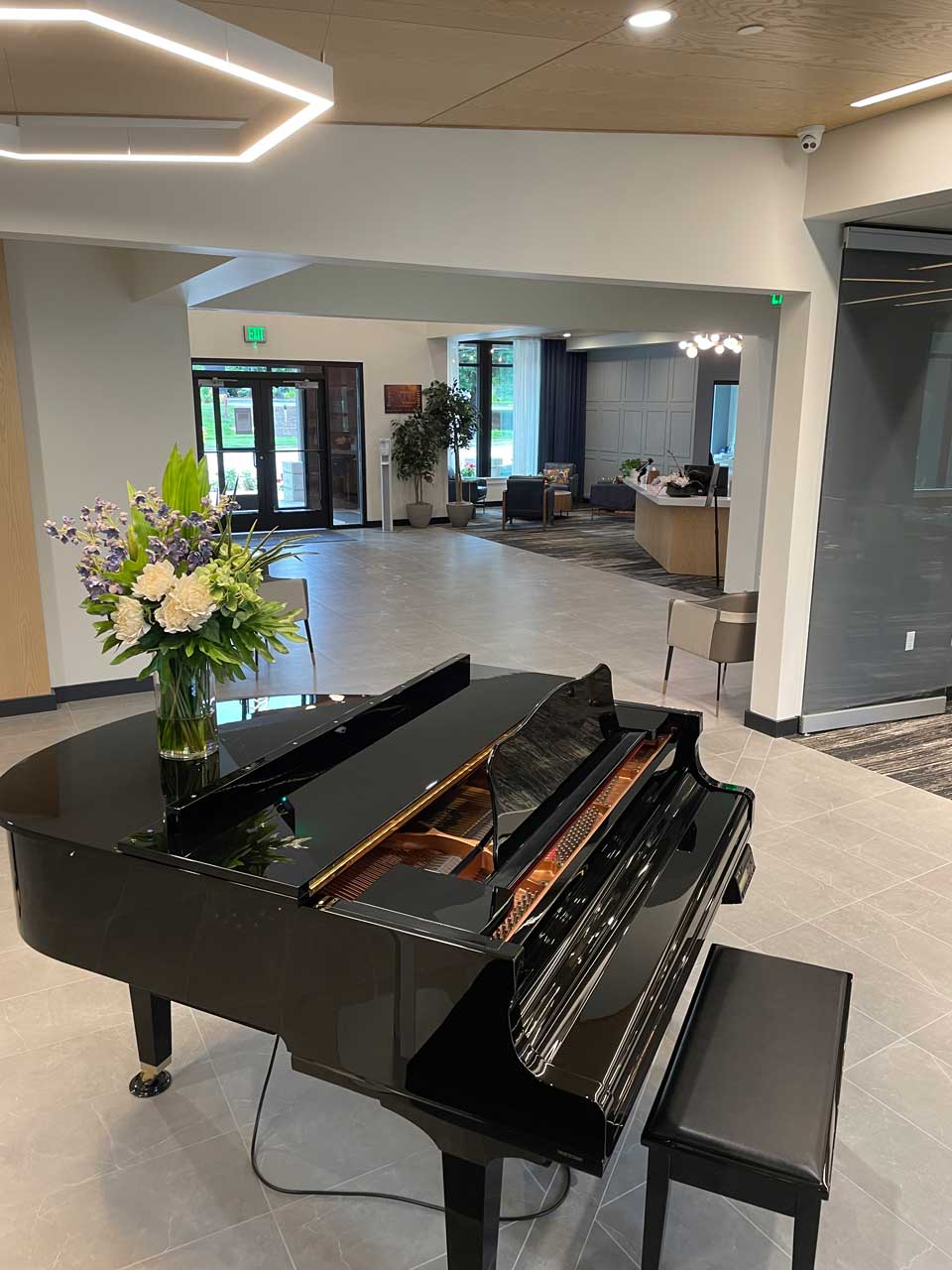 Interior lobby featuring a grand piano and flowers