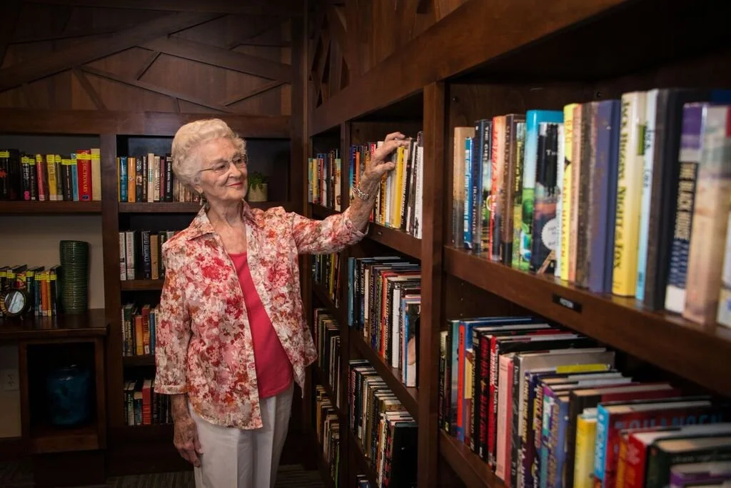 Resident browsing books in a cozy library corner